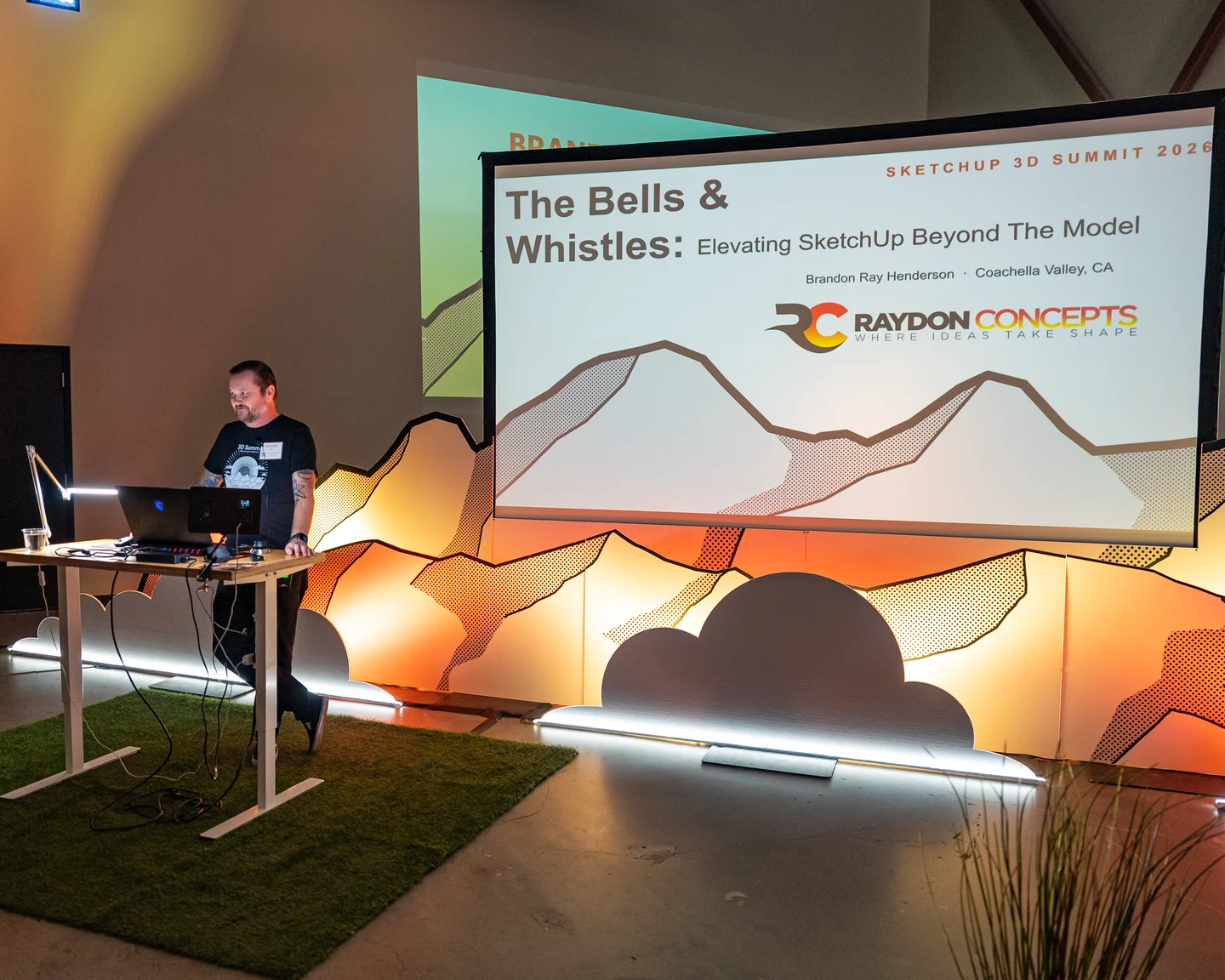 Brandon Ray Henderson presenting onstage at SketchUp 3D Summit 2026, beside a screen displaying his Raydon Concepts presentation.