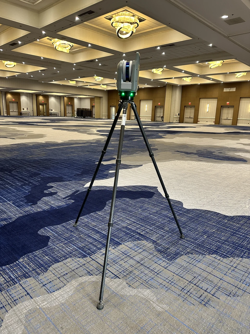 A Trimble X9 laser scanner on a tripod documenting a ballroom interior.